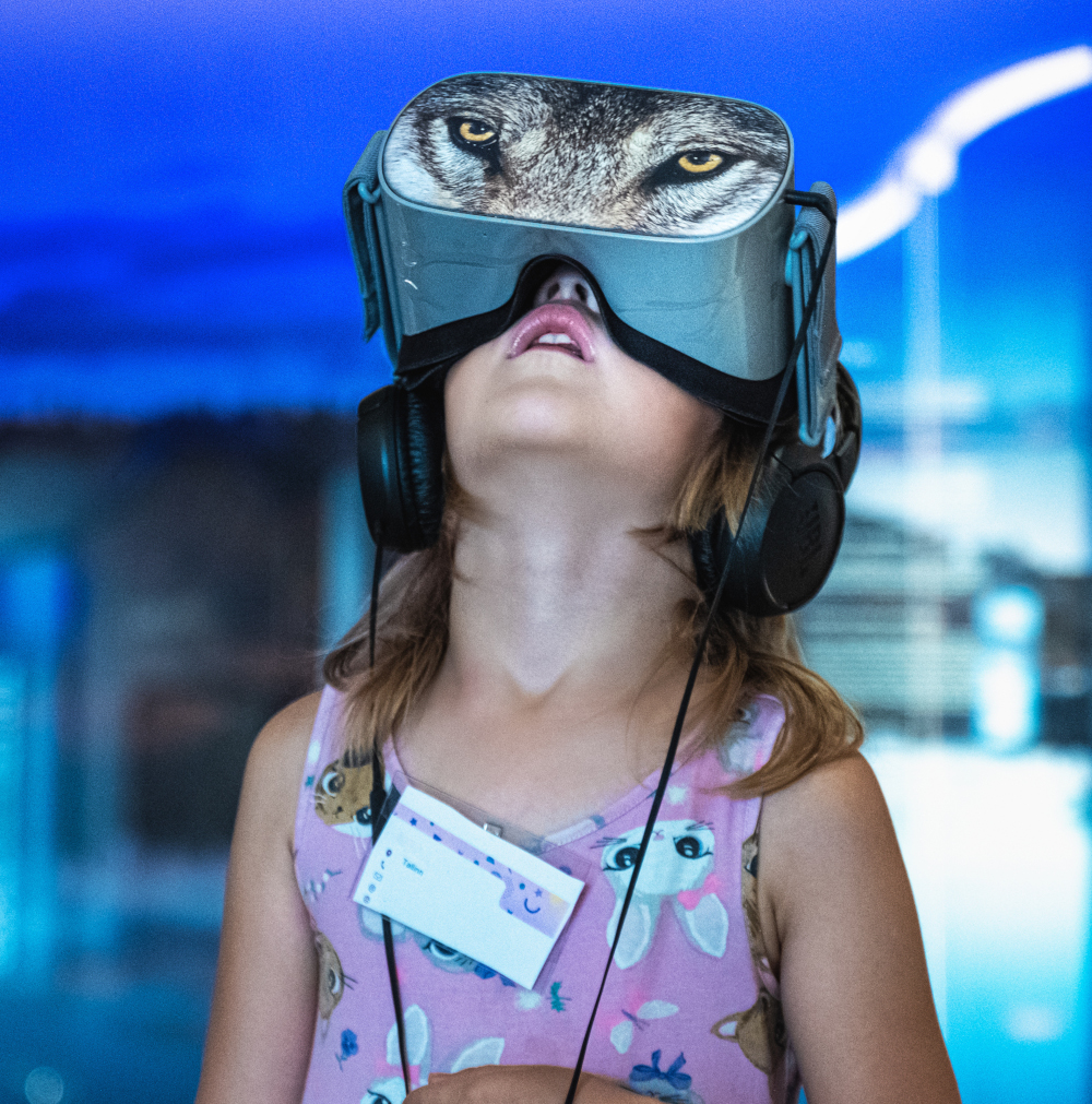 Väike tüdruk vaatab virtuaalreaalsusprillidega filmi