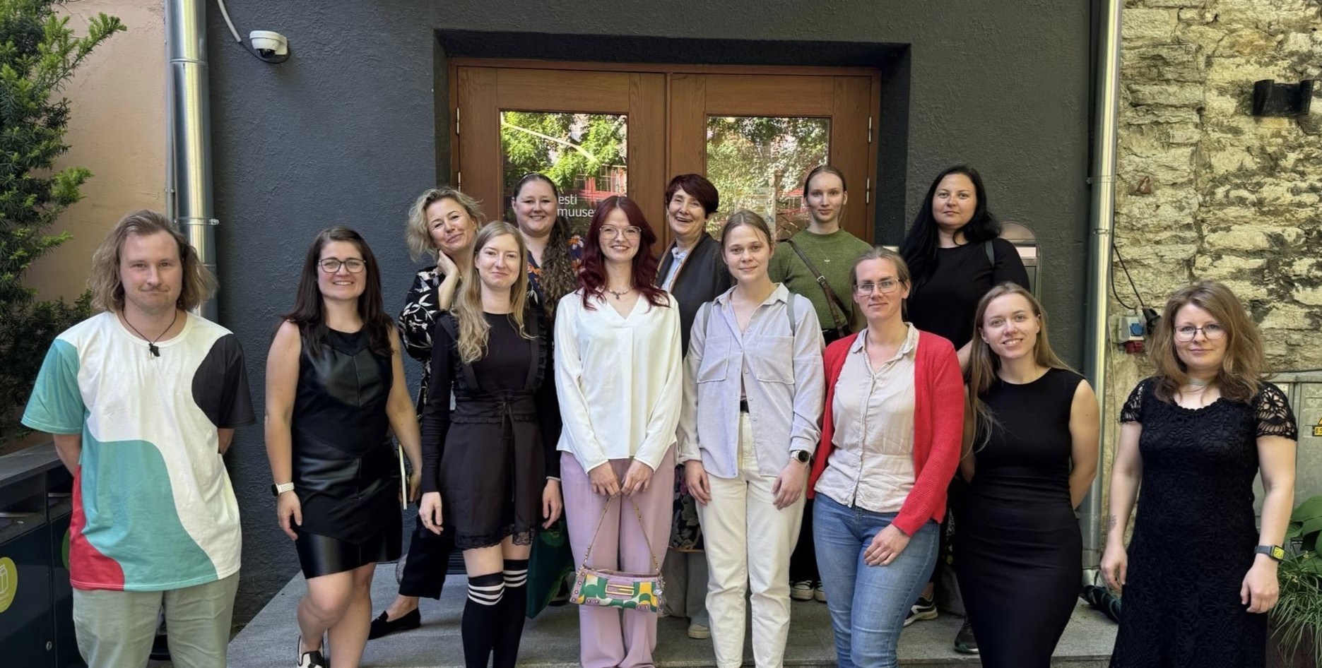 Eesti Loodusmuuseumi 2025. aasta praktikandid muuseumi välisukse ees trepil